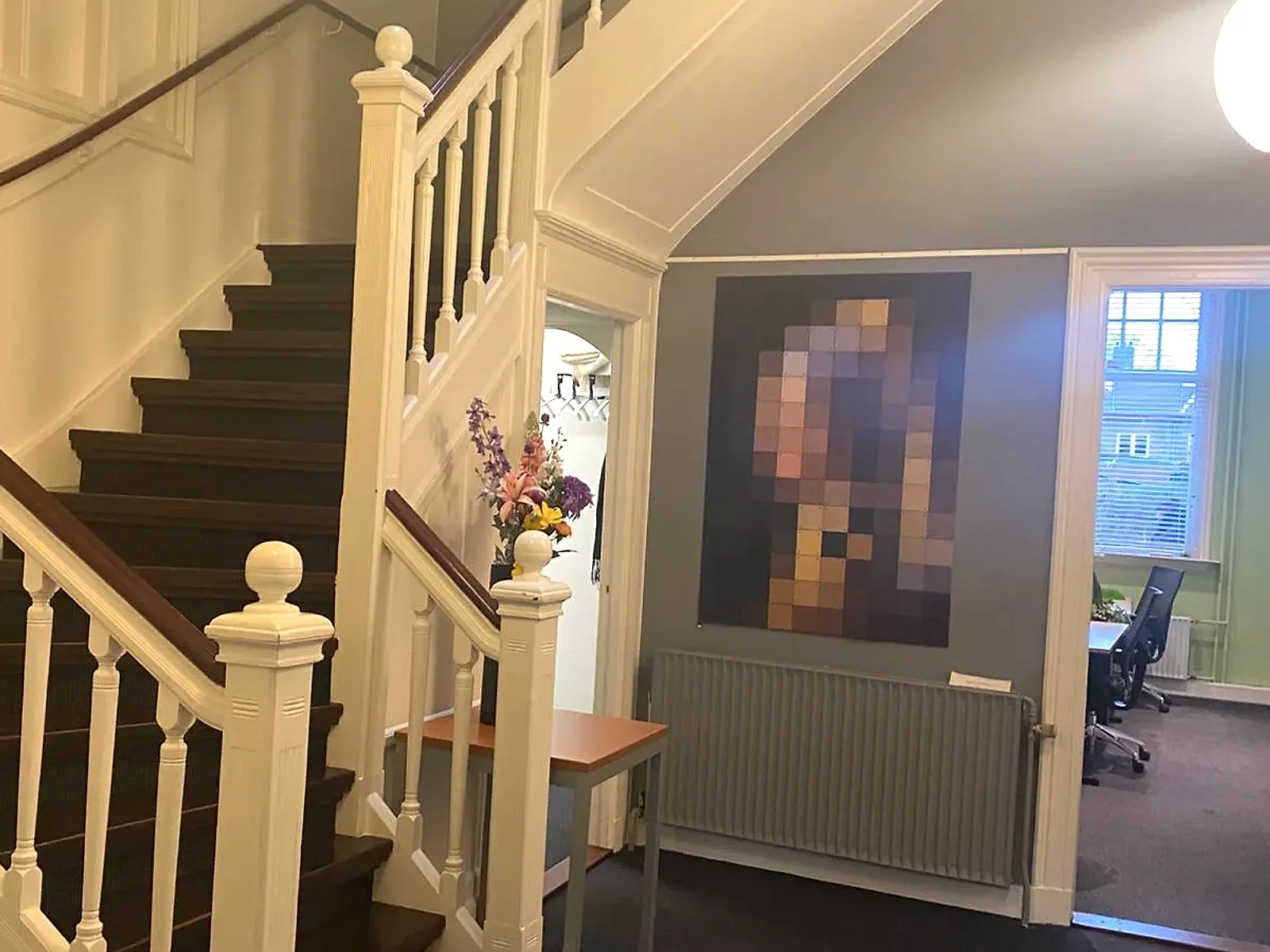 Sierlijke trappenhal met kunstwerk en bloemen